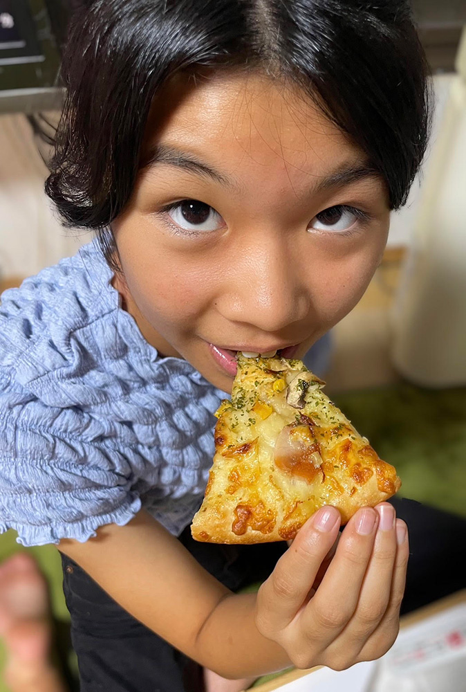 美味しそうにピザを食べる子どもたち。